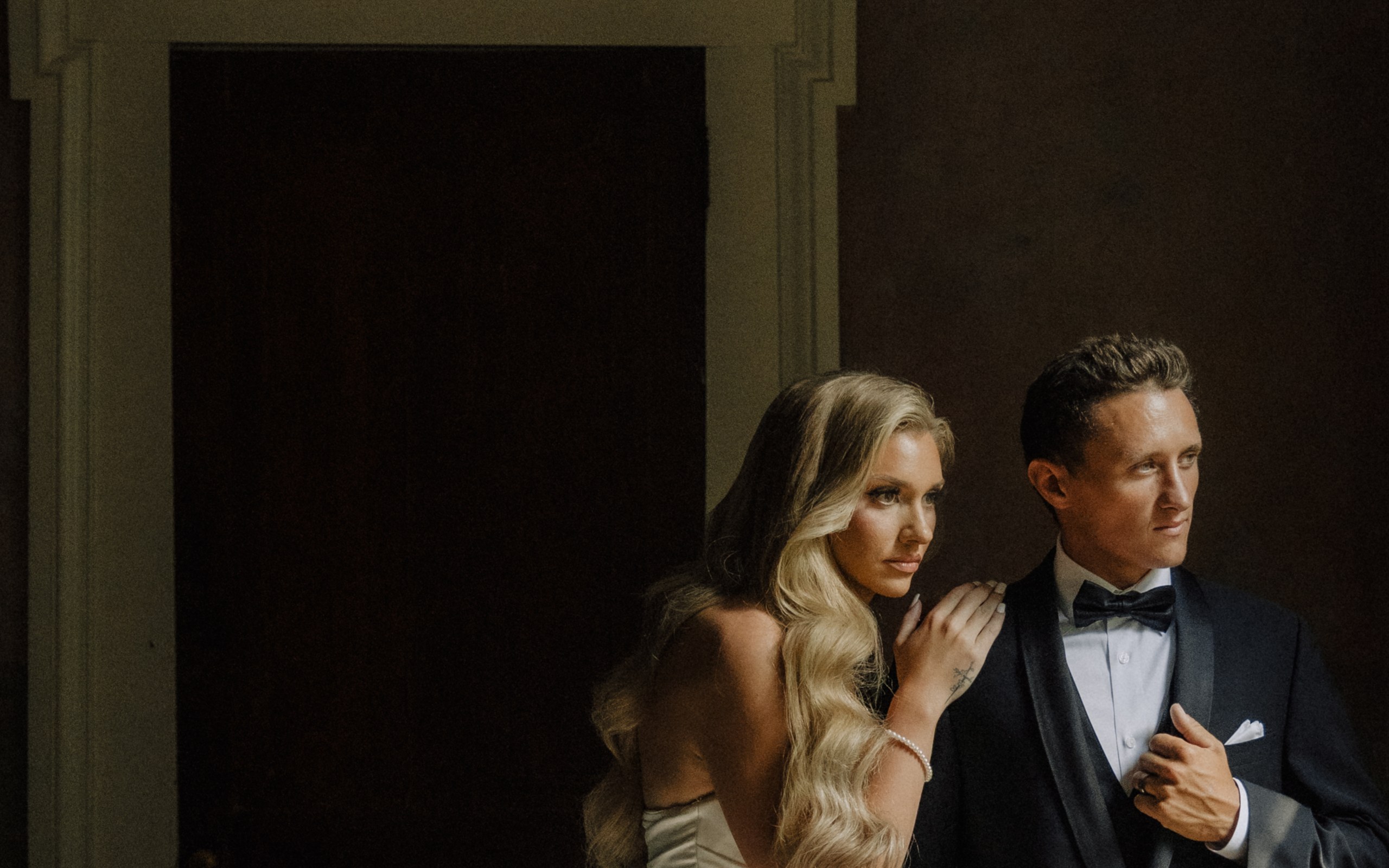 Maddie and Brandon standing together in window light at Riverwood Mansion